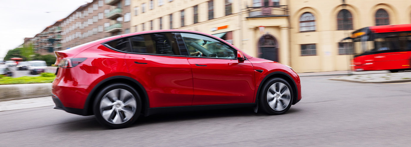 En bil av typen Tesla Model Y kjører i en rundkjøring i by