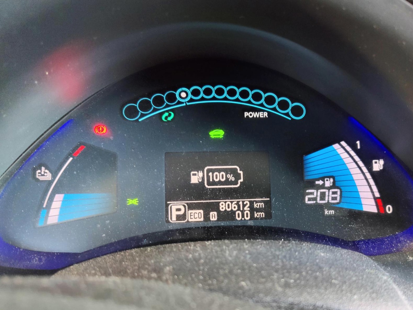 Instrumentpanel som viser 100% batteri og 208 km gjenværende rekkevidde.