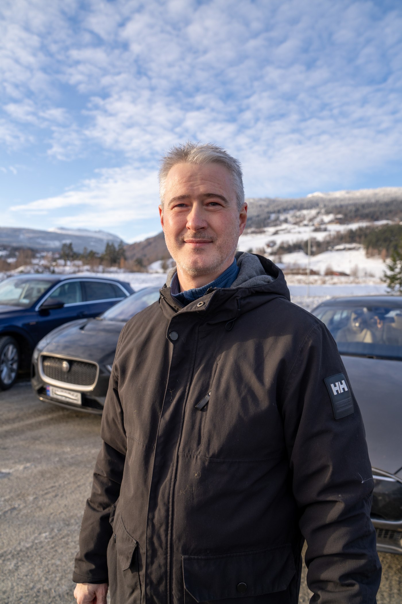 Smilende mann foran testbiler