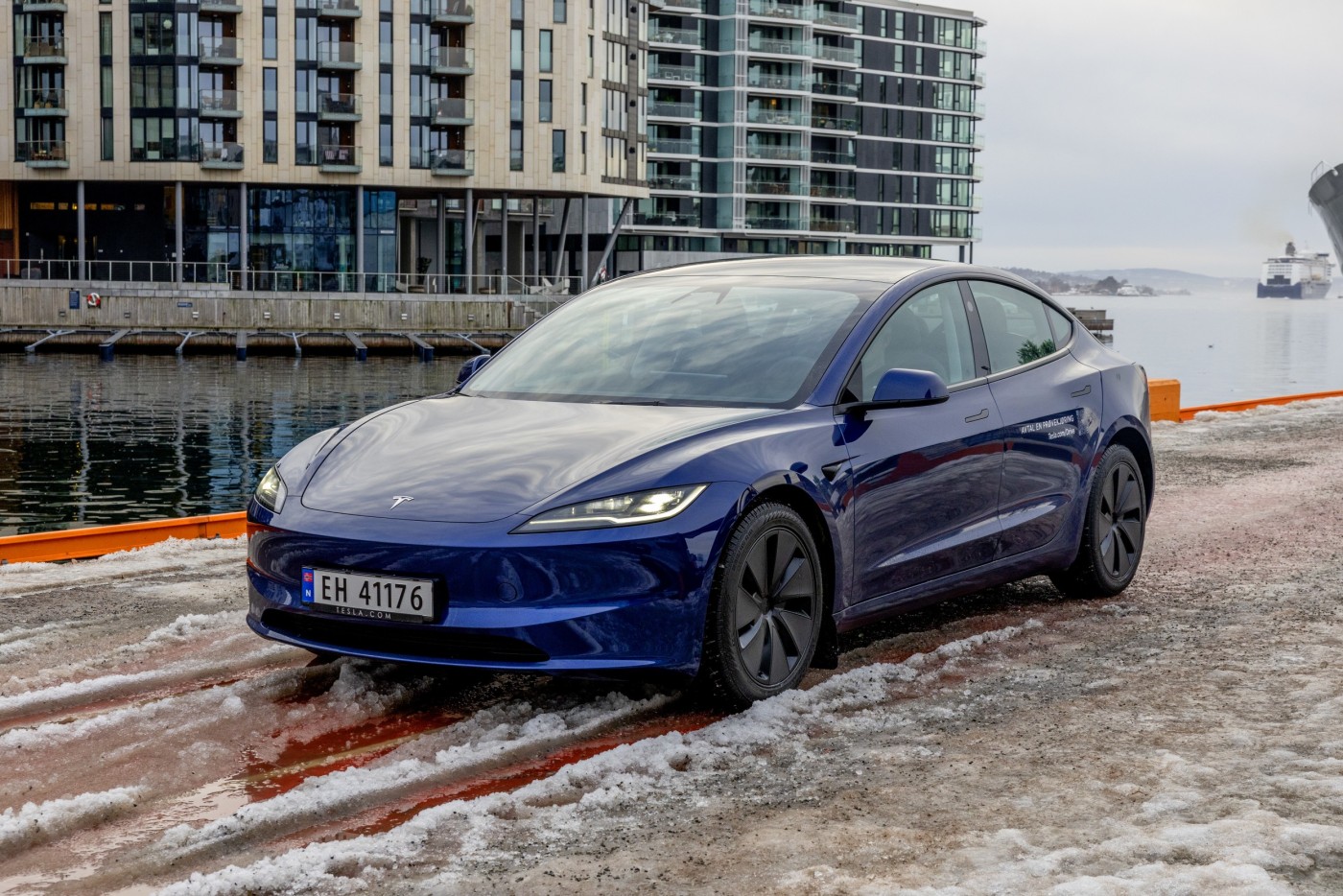 Blå Tesla Model 3 på kaia