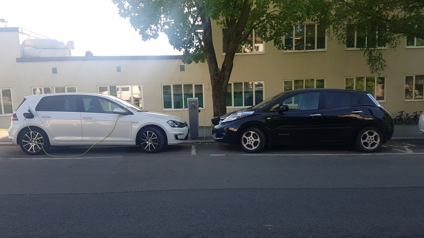 To elbiler står parkert langs gata mens de lader