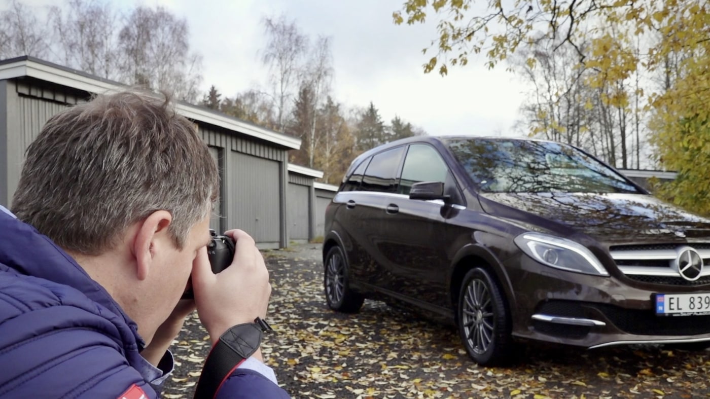 mann fotograferer svart bil