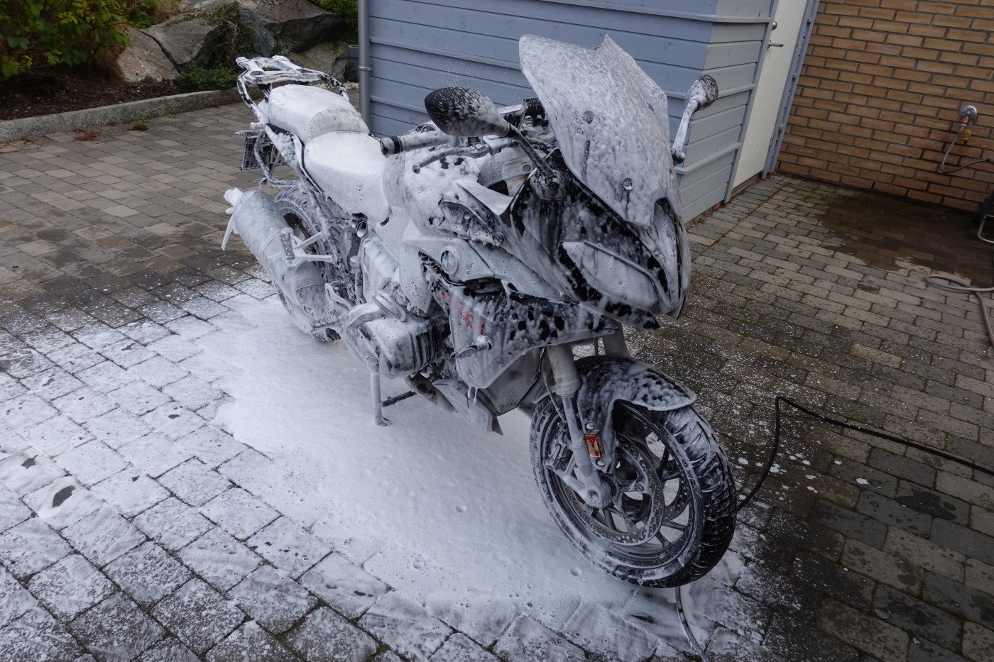 Motorsykkel blir vasket ute.