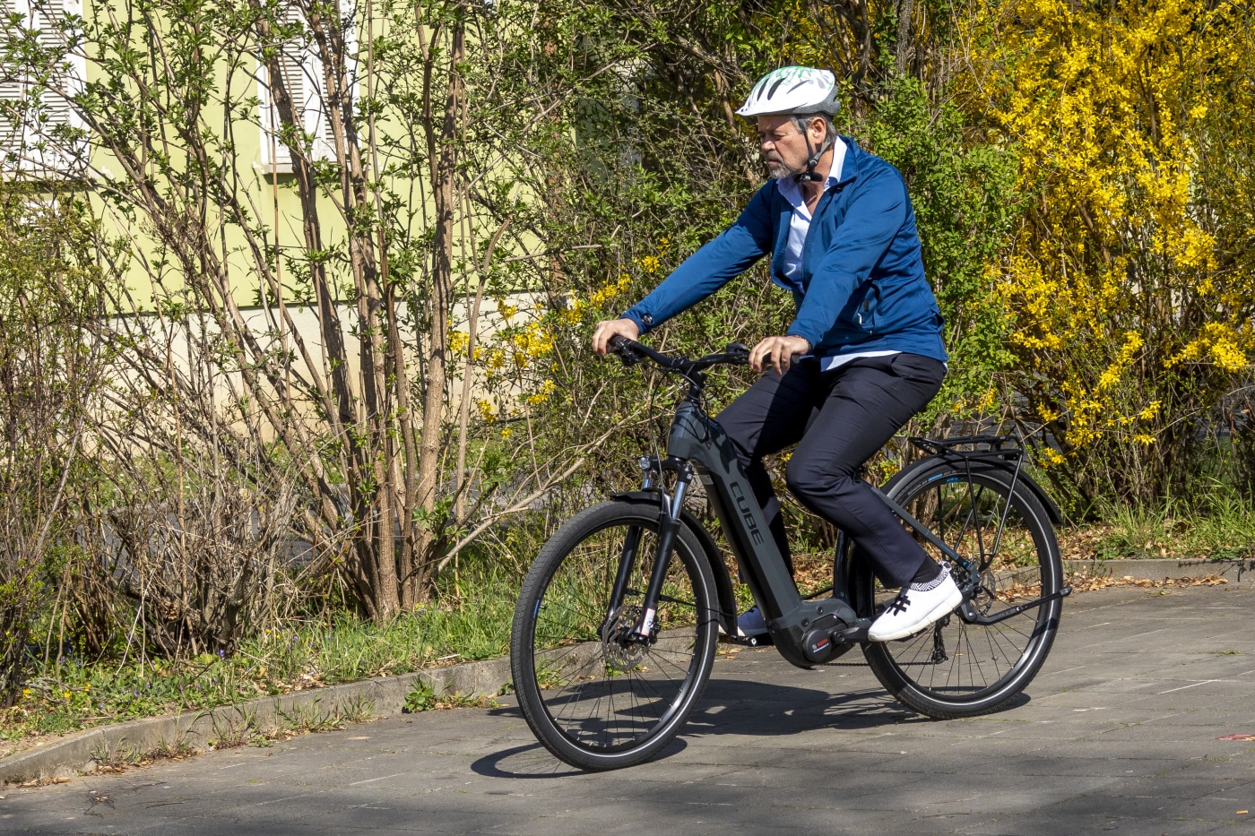 Mann sykler på en landevei og utfører test på elsykkel.