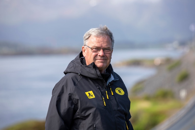 Mann smiler inn i kameraet
