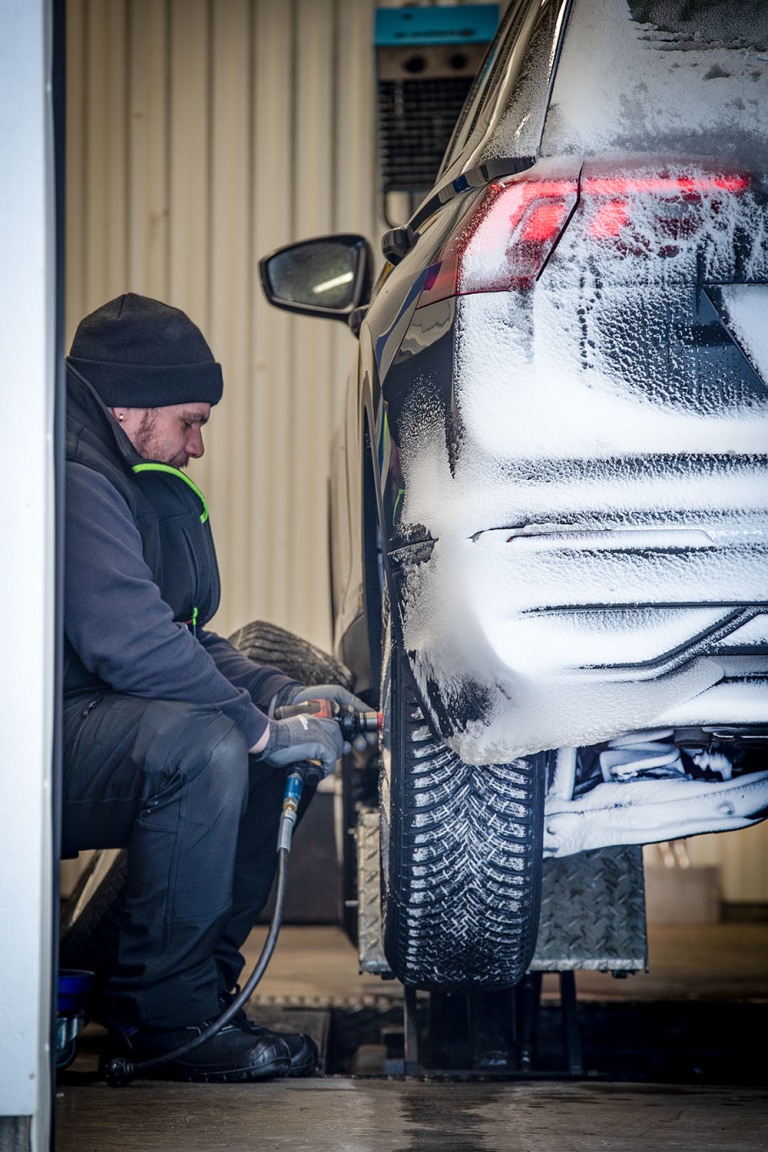 Mann skifter hjul på bil