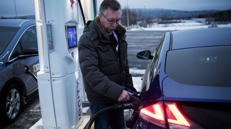 mann bruker ladestasjon