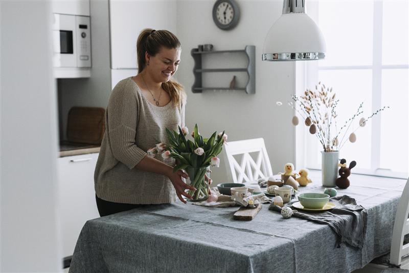 Dame på kjøkkenet med påskepynt
