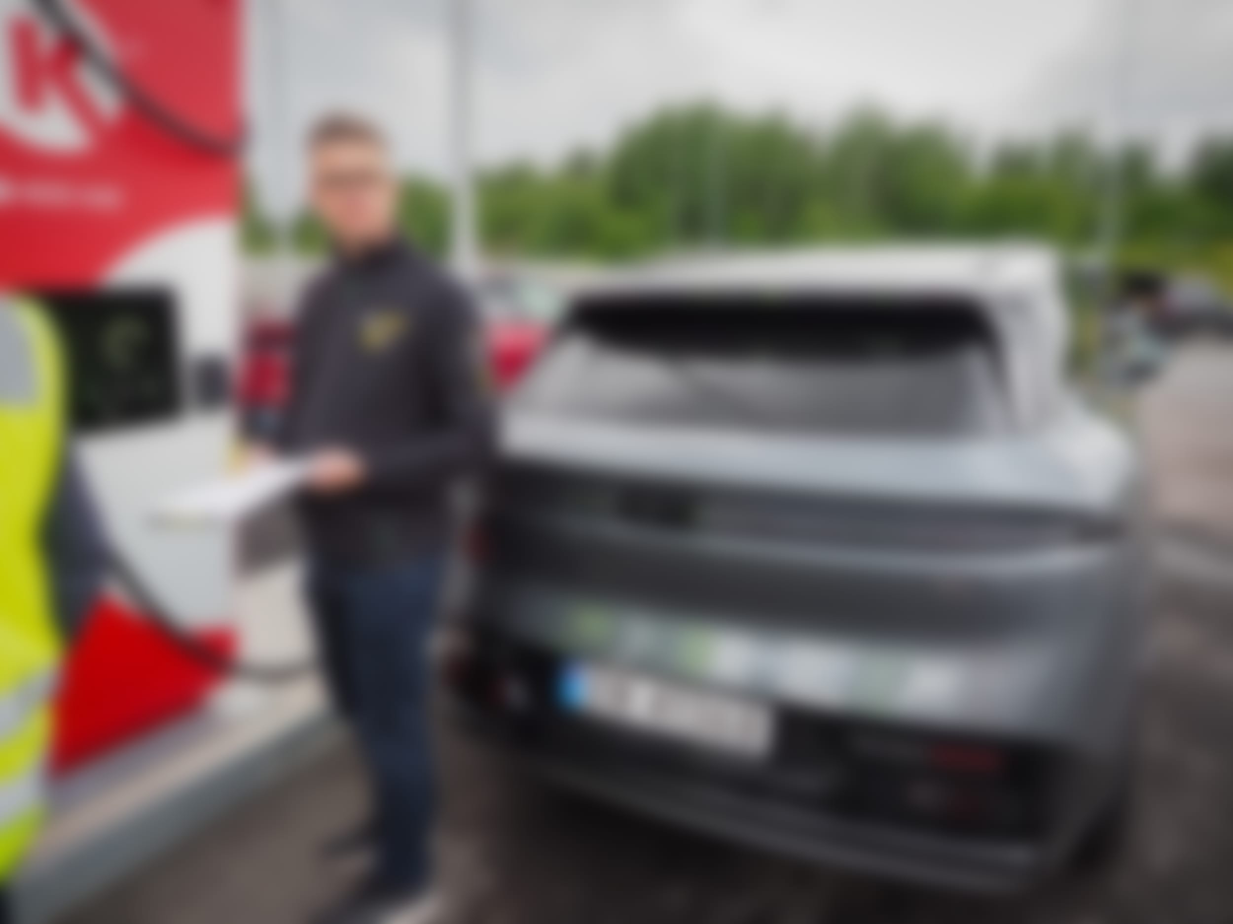 Kommunikasjonsrådgiver Nils Sødal ved ladesøylen med grå Zeekr 7X