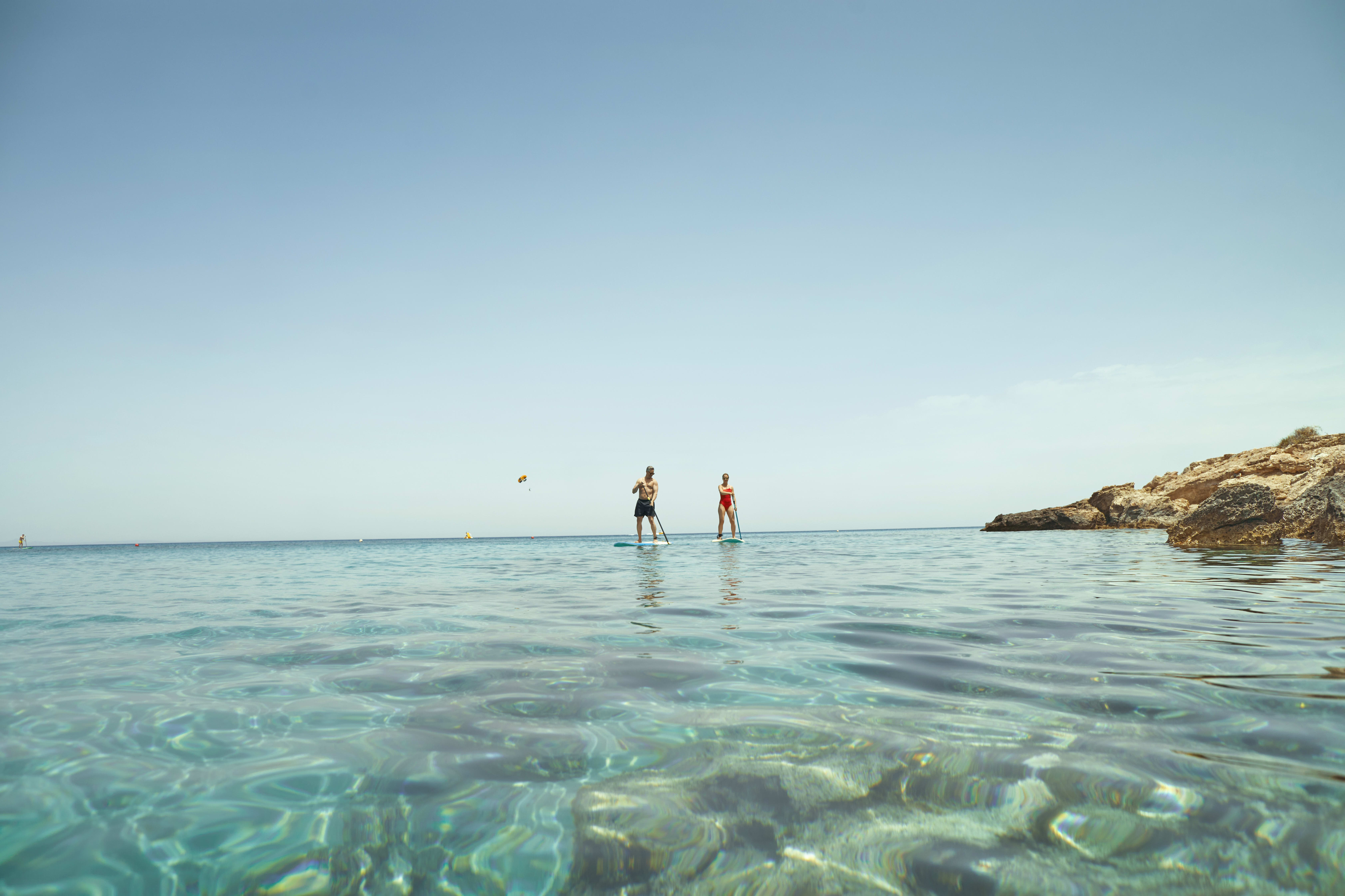 Bilde av noen som padler sup i havet