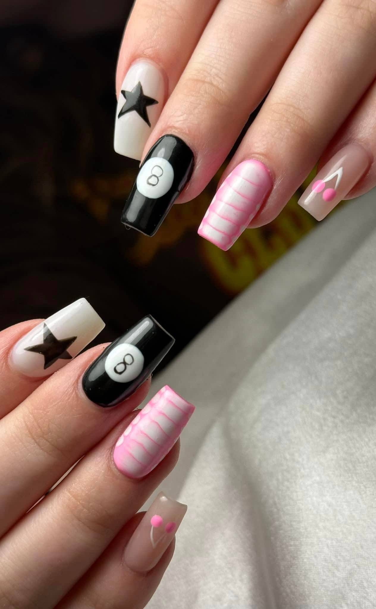 Black and white nails with star and pool ball designs.