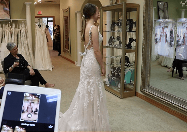 Bride, family and friends reviewing photos on the Magi Mirror while attendant chooses photos from Magic Mirror ipad app.