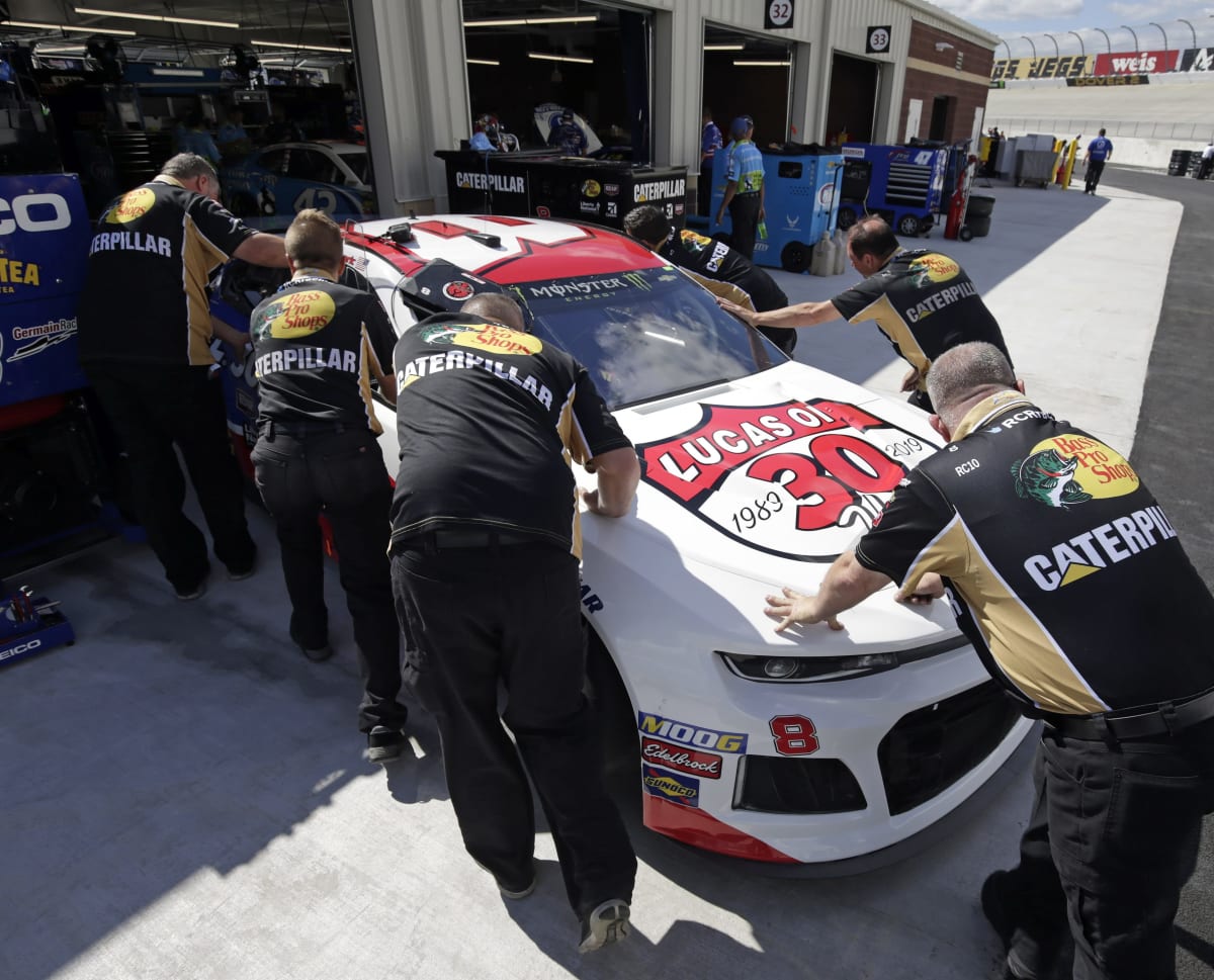The No. 8 crew push Daniel Hemric's Lucas Oil Chevrolet into the garage stall prior to Friday's opening practice at Dover.