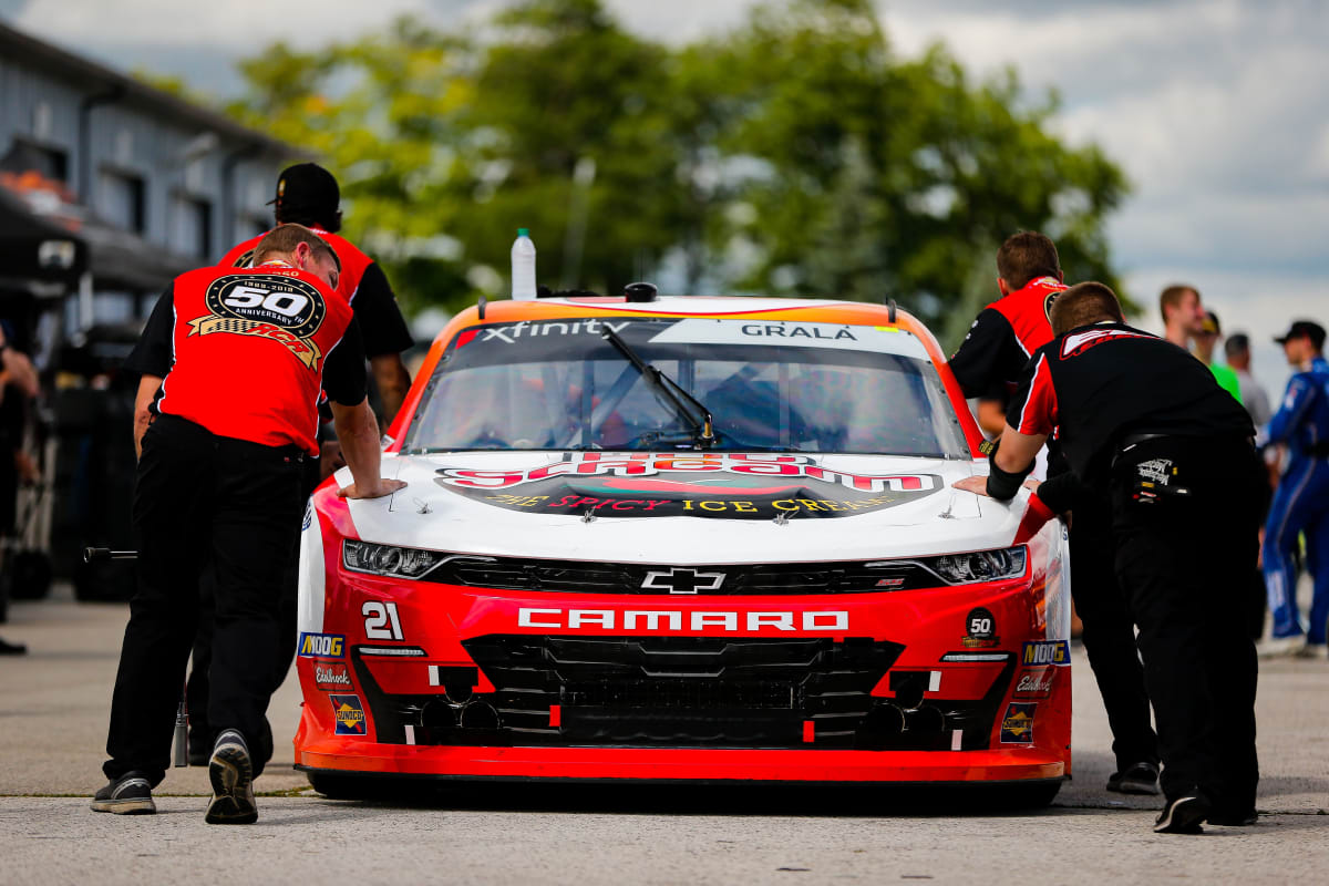 The No. 21 team pushes Kaz Grala's Hot Scream Chevrolet through the garage during pre-race inspection at Road America.