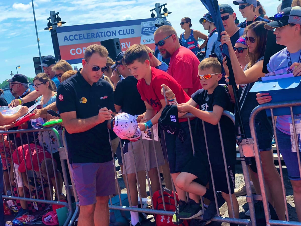 Daniel Hemric signs autographs for young NASCAR fans on his way into the driver/crew chief meeting Sunday at Michigan International Speedway.