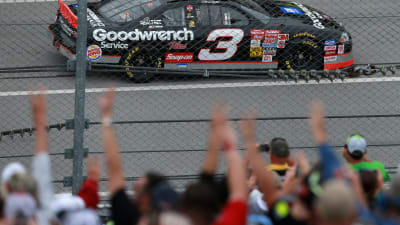 Fans flash the No. 3 as Richard Childress drives Dale Earnhardt's 2000 race-winning GM Goodwrench Chevrolet during pace laps on Sunday.