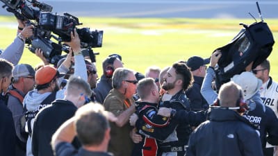 Tyler Reddick is held as a group gathers around him after a scuffle broke out with Cole Custer and his team after Saturday's NASCAR Xfinity Series race at Kansas Speedway.
