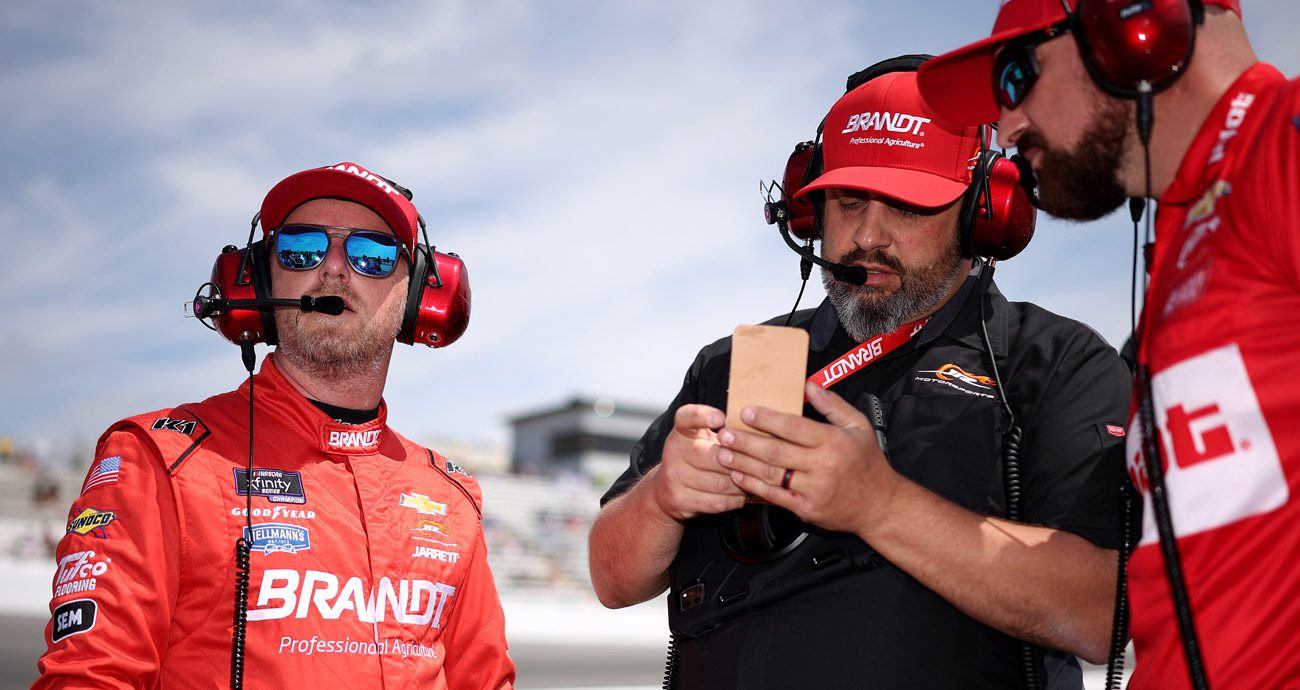 Justin Allgaier and Jim Pohlman speak during NASCAR practice.