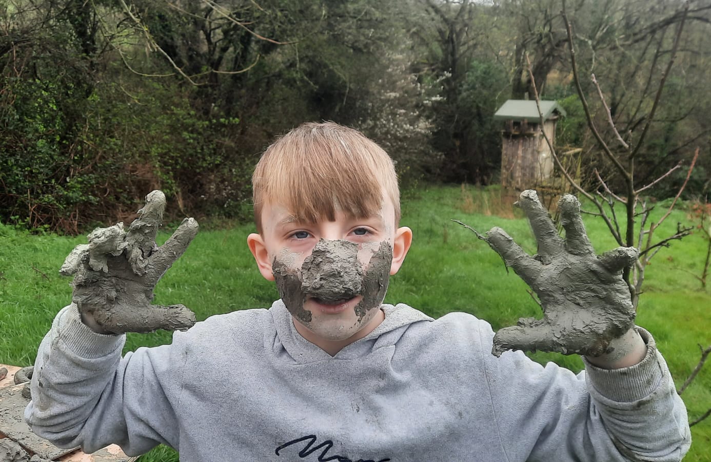 Student with rather a lot of clay on their face