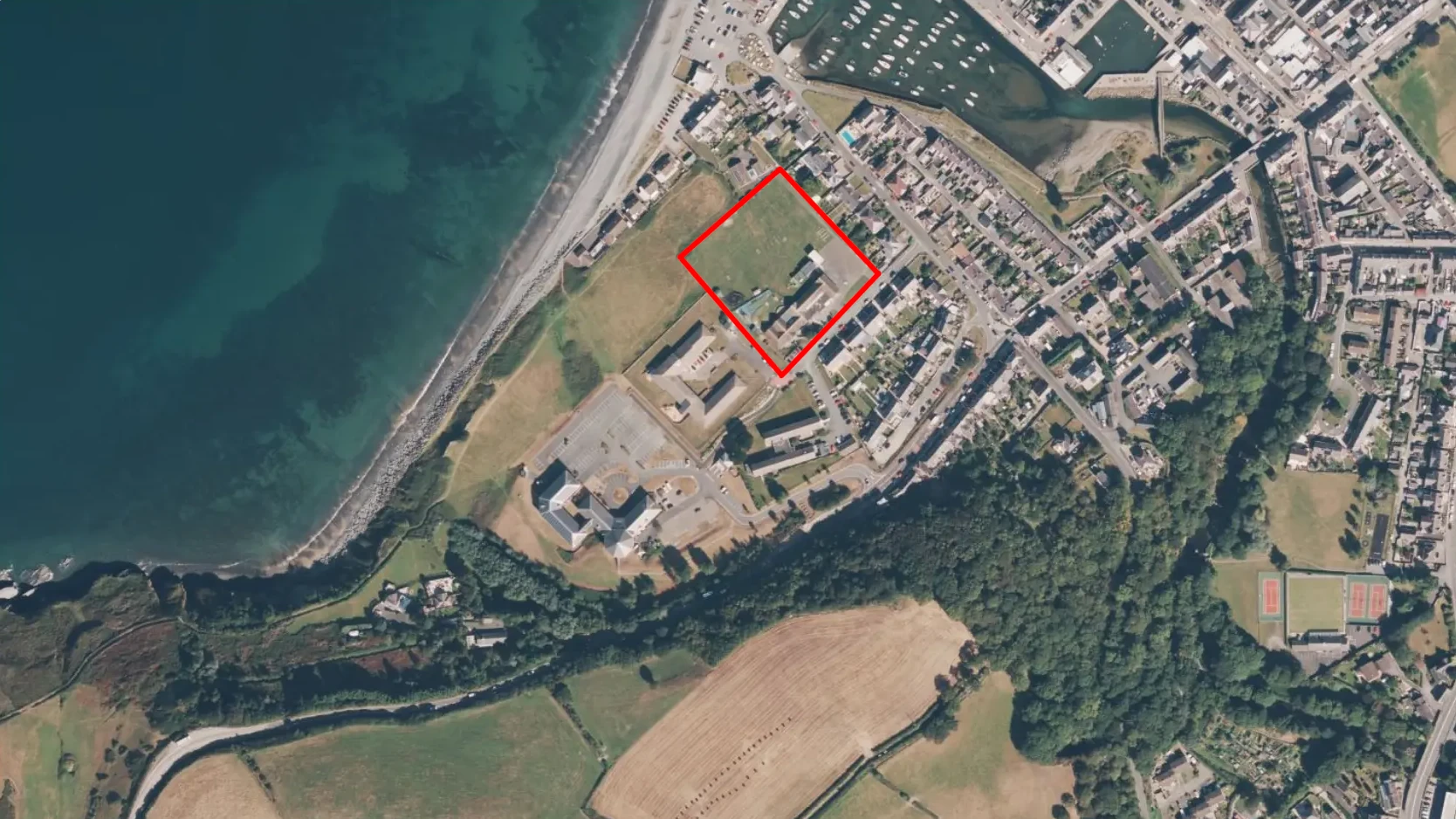 Satellite photo showing Ysgol Gynradd Aberaeron situated right next to the coast, grassland, river and woodland, all accessible by footpaths