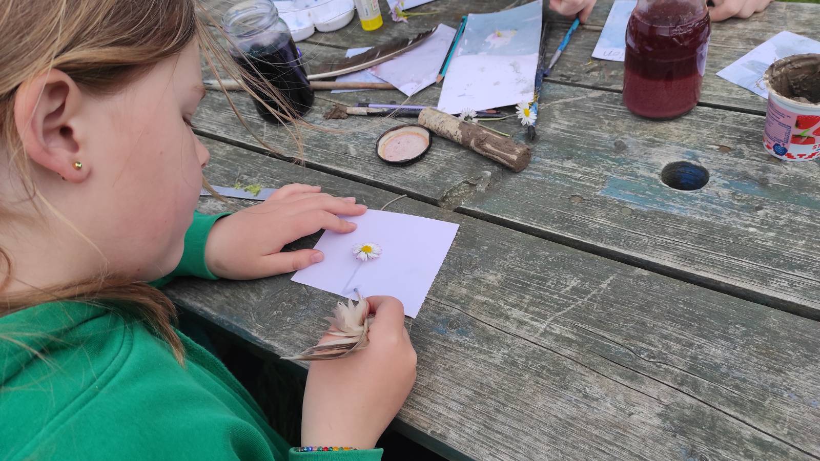 Student painting around a Daisy flower