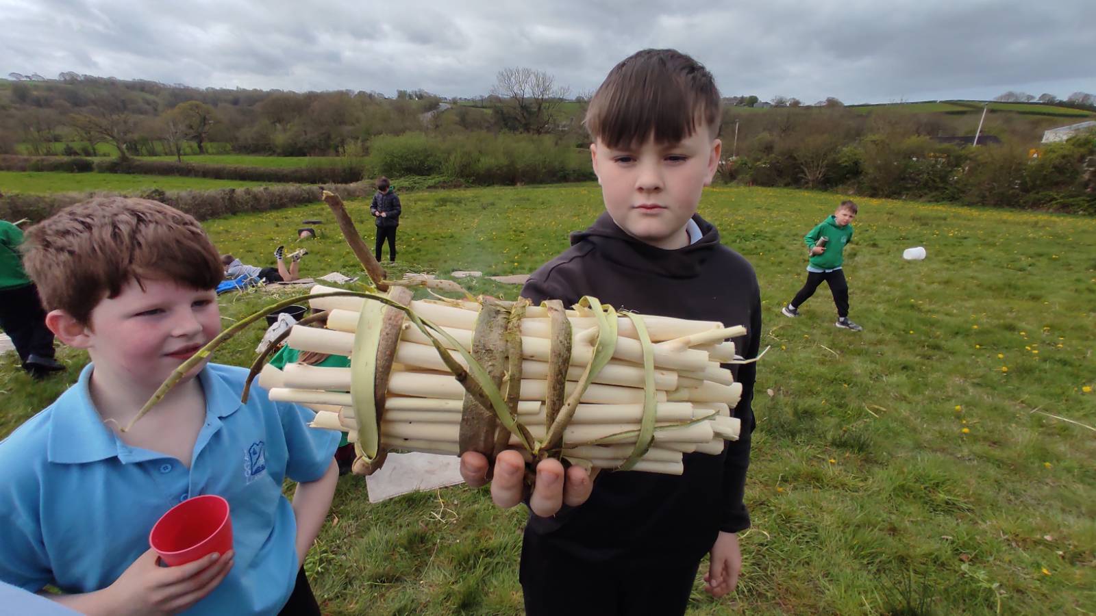 Student with a bundle of willow sticks.