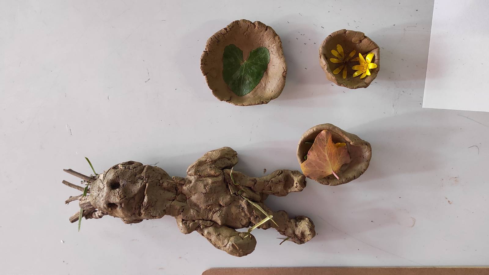 Clay figure and clay bowls on the desk.