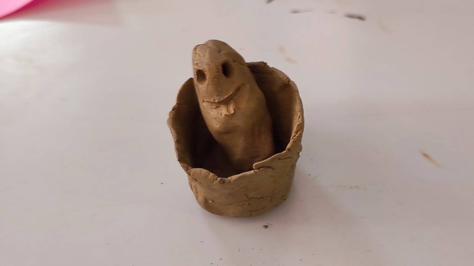 Clay figurine in clay bowl.
