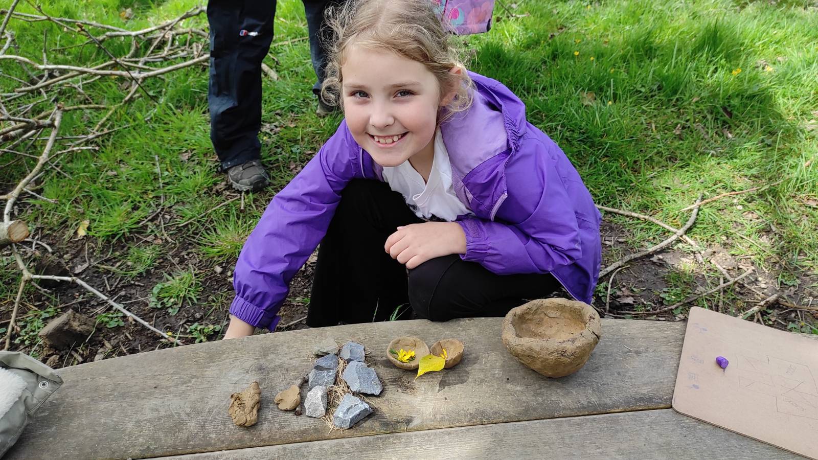 Student with clay bowls and stone collection.