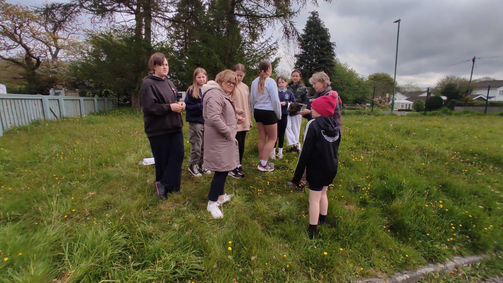 Nature group out at the front of the school, looking at plants in the school grounds before setting off for the river.