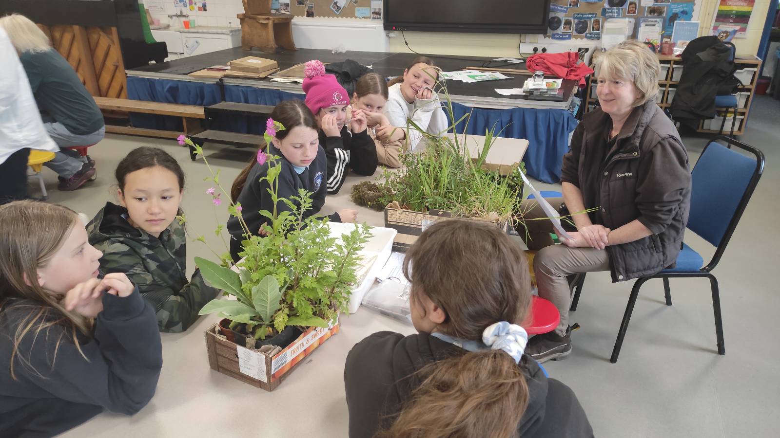 Sheena talking plants with students in the school.