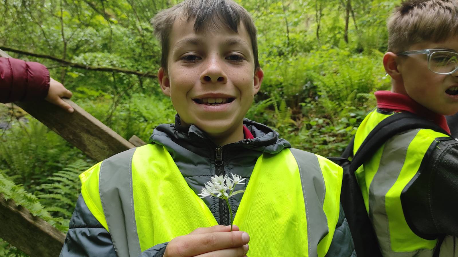 Smiling student with the white flowers of Wild Garlic