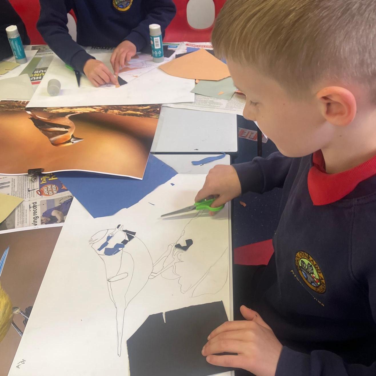 Student putting the blue coloured card as collage on the pencil drawing of a bird