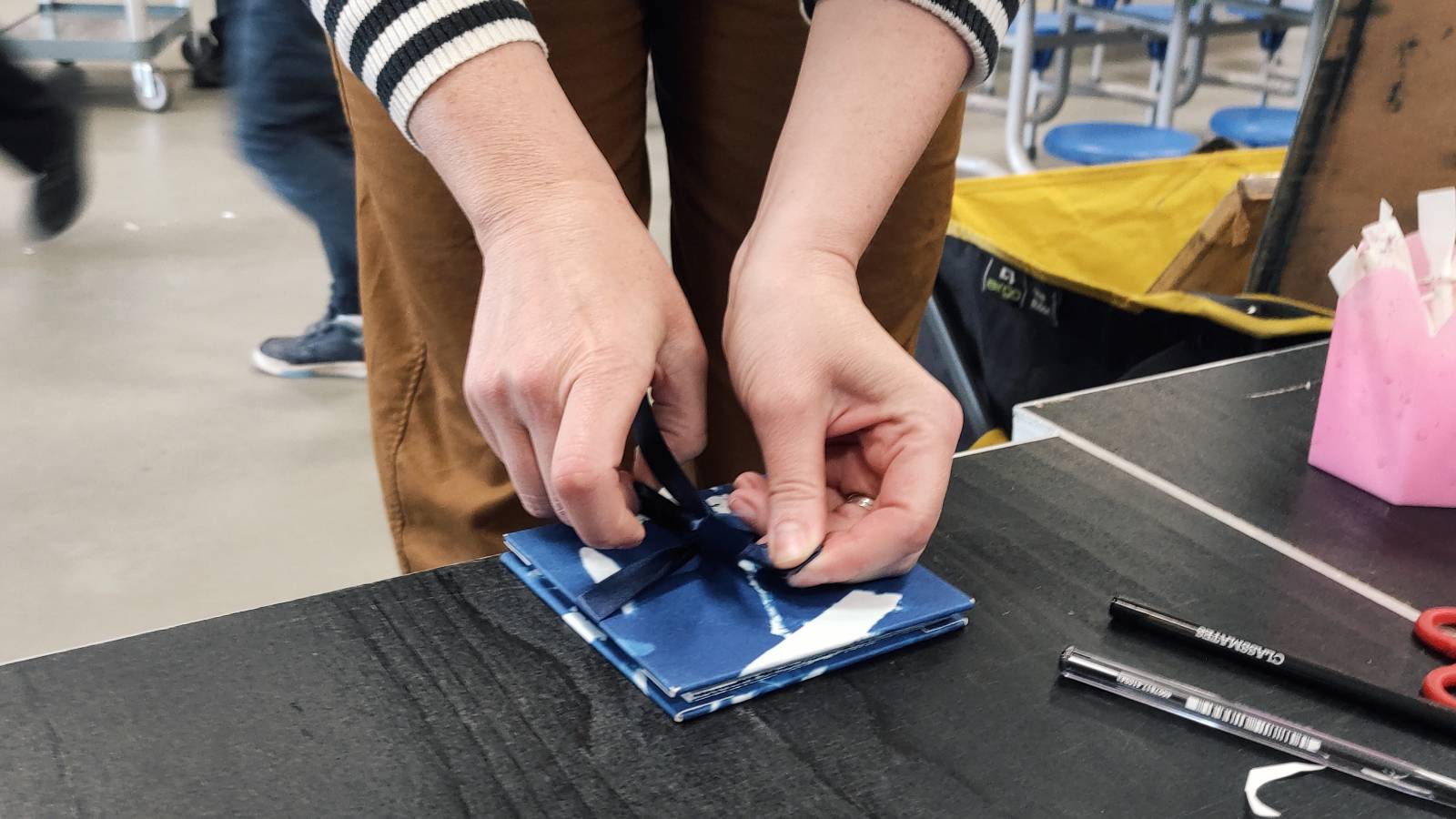 Artist Marian Haf showing how to tie the ribbon around the cyanotype
