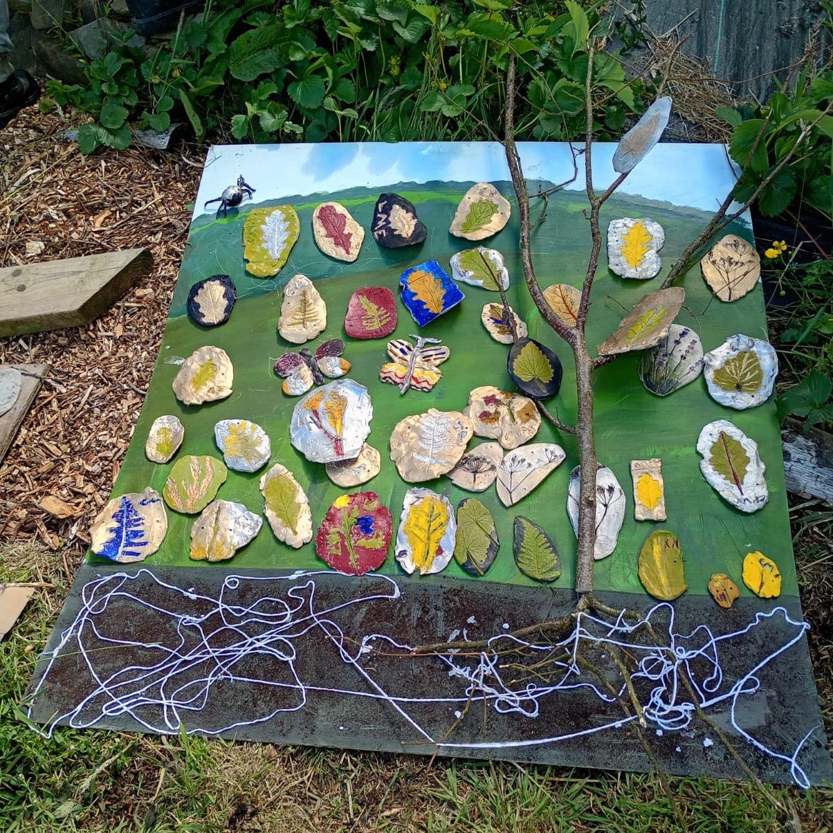 Diorama of painted clay artefacts on naturalistic backdrop