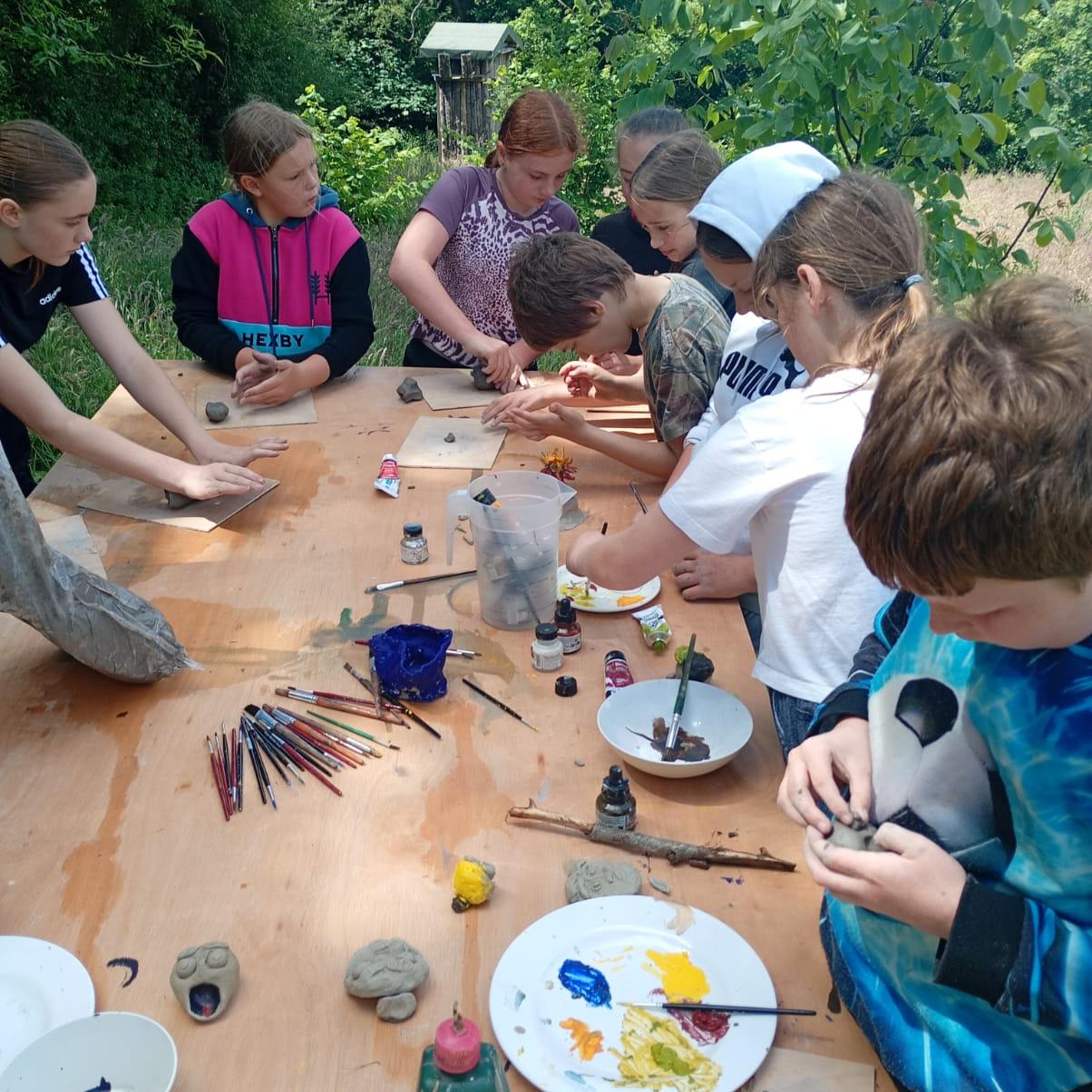 Students painting at the art table