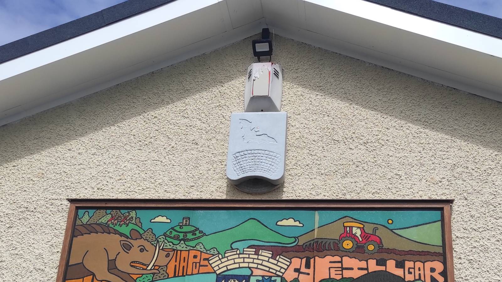 Grey bat box at top of wall beneath apex and eaves