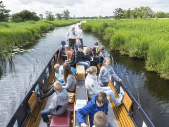 Een boot vol leerlingen tijdens het lesprogramma van De Wieden