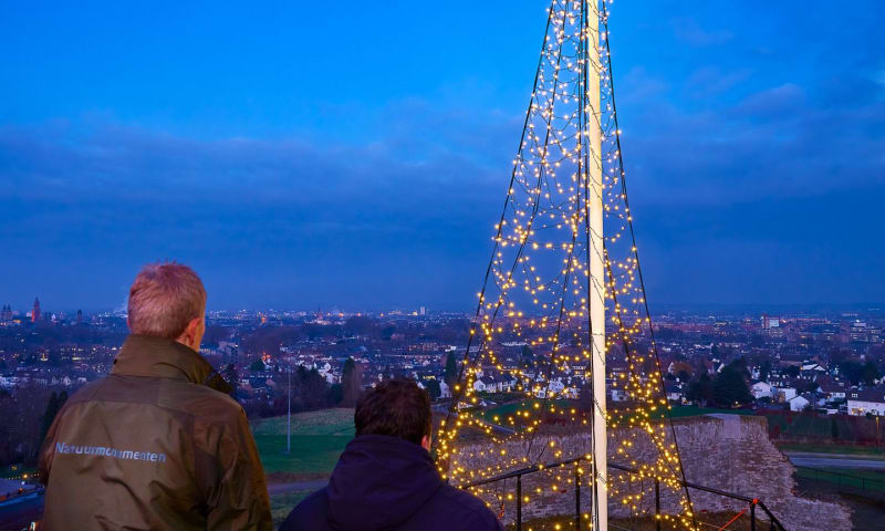 boswachter steekt kerstboom aan