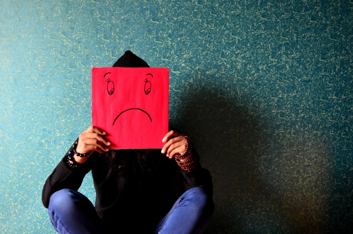 man with a sad mask in front of him