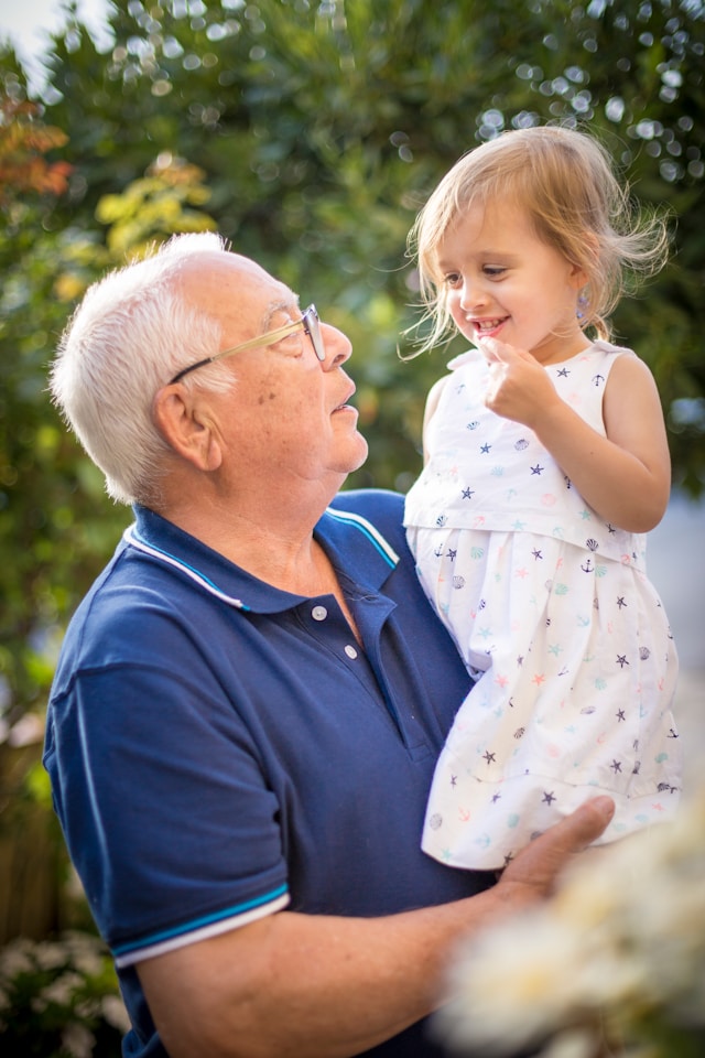 Grandfather holding up granddaughter