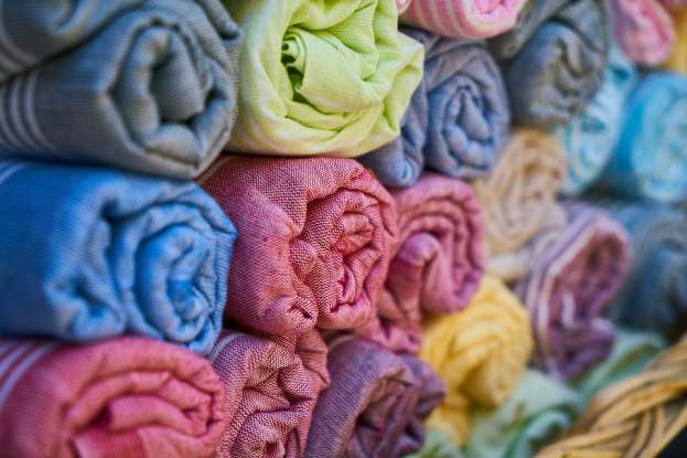 32. A textile factory uses 5 yards of fabric to make a dress. How many dresses can be made with 255 yards of fabric?