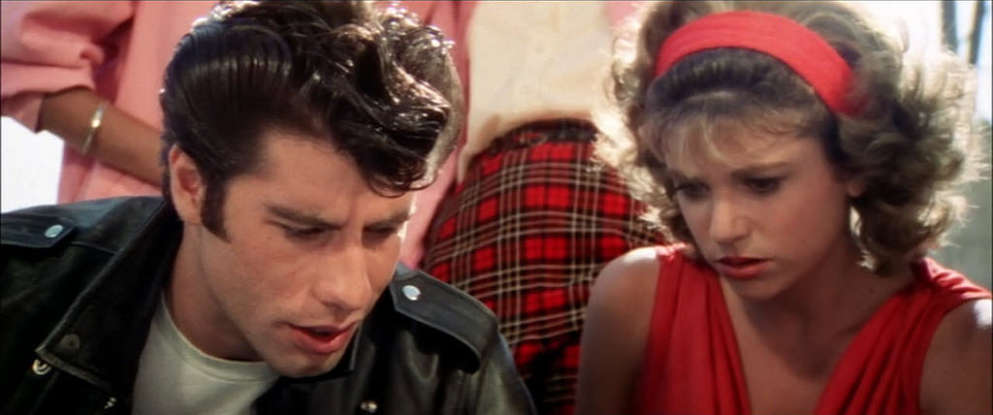 26. What does Danny give Sandy when he asks for her forgiveness at the drive-in?
