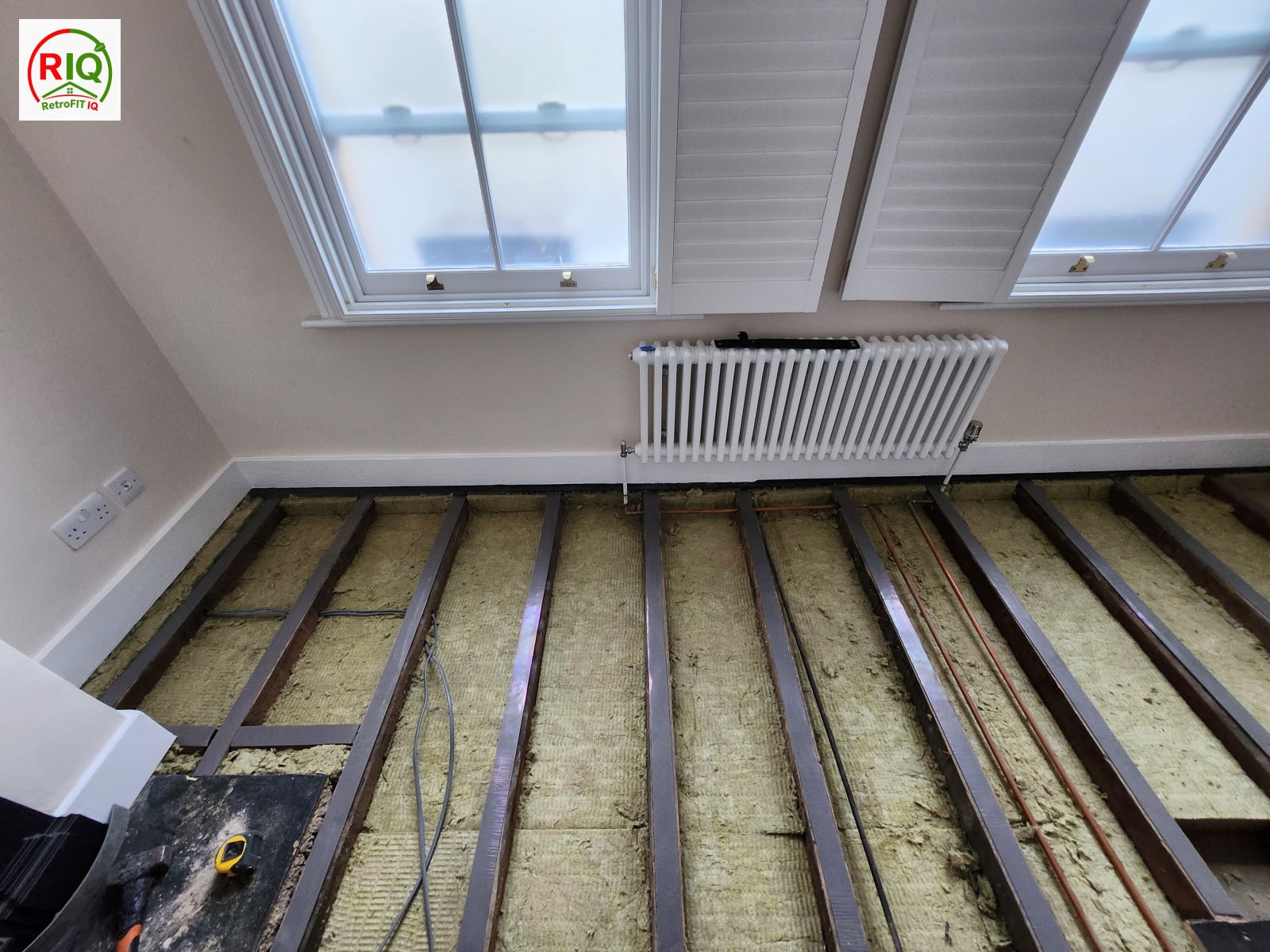 Rockwool and resilient acoustic bars fixed across joists to decouple a new soundproof floor — East London