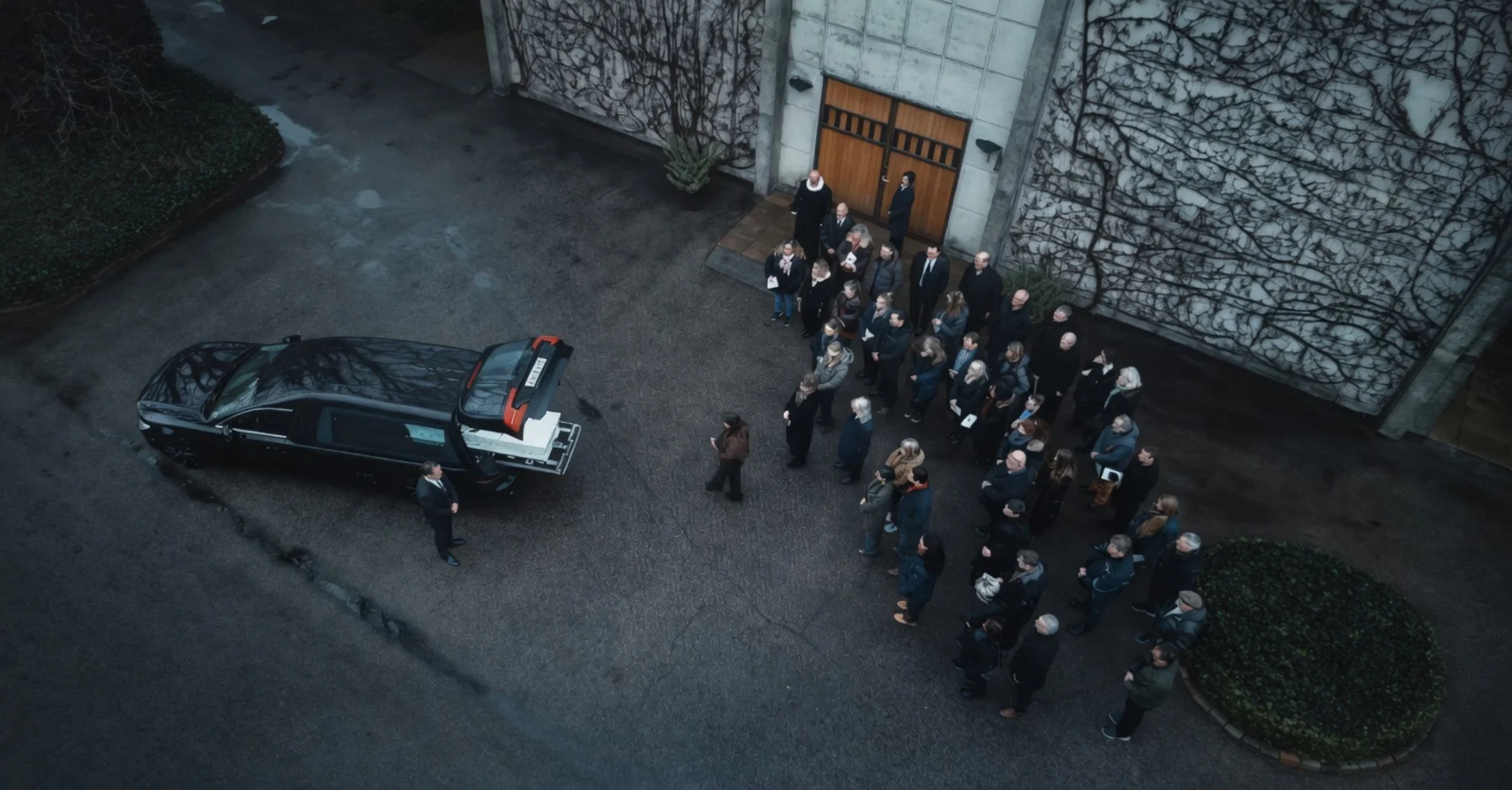 Bedemanden og Kastanjemanden. Scene fra sæson 2 hvor en af seriens deltagere begraves og køres bort i rustvogn fra Mariebjerg kirkegård.