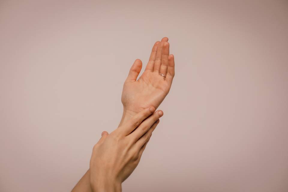 a person gracefully pressing their left forearm with their right hand