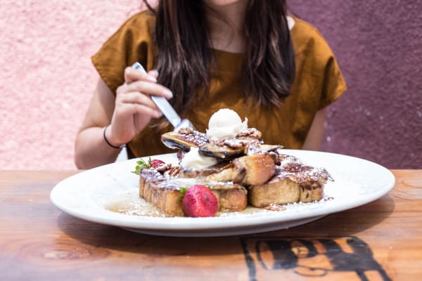 never-better-hash-house-woman-eating-large-stack-of-waffles