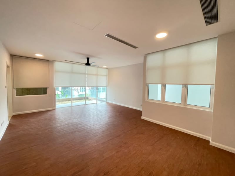cream light-filtering roller blinds lowered over a side window and a sliding door in this empty apartment