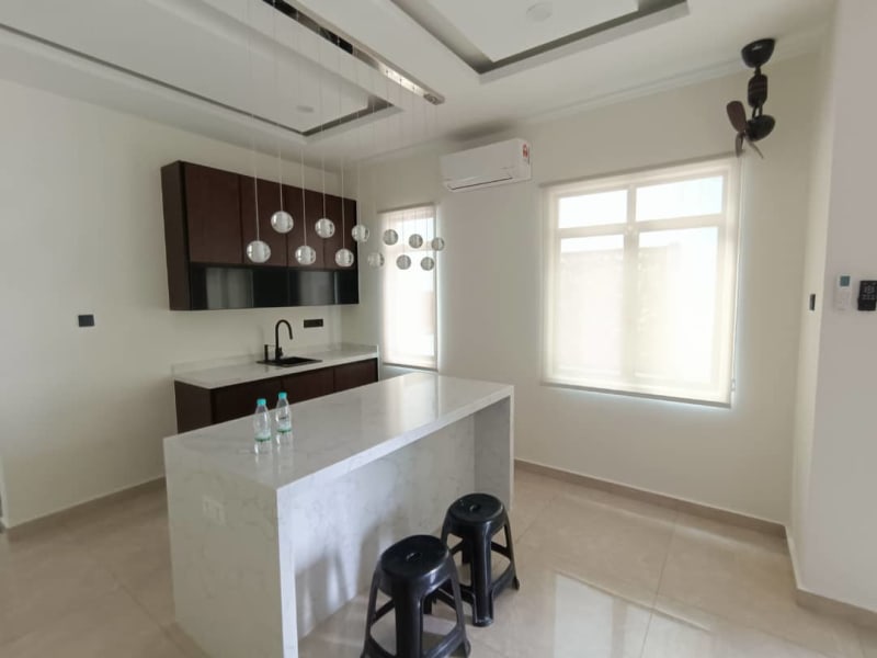 white sunscreen roller blinds lowered over two kitchen windows, a neighboring building faintly visible through the mesh