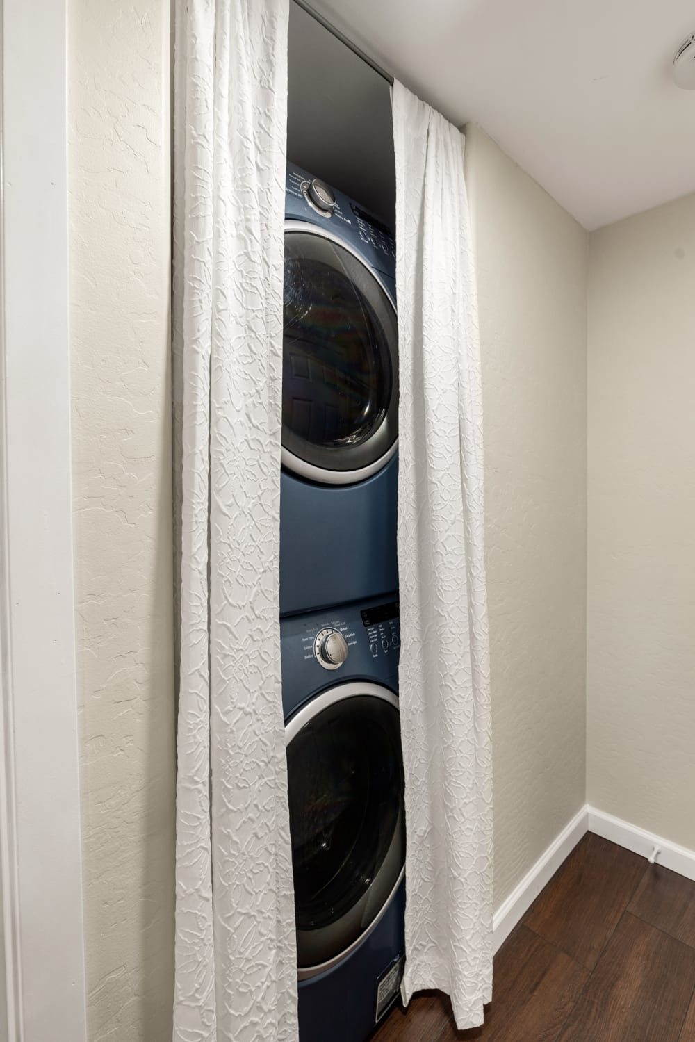 
The laundry area features a sleek, modern stacked washer and dryer, offering efficient use of space and advanced functionality for all your laundry needs.